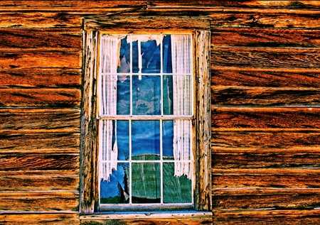 Closeup photo of a window with tattered curtains at Bodie State Historical Park in California.の写真素材