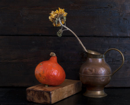 Autumn still life with pumpkin and dried flower on dark wooden backgroundの写真素材
