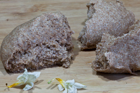 Bread on the cutting board with white flowers on the background.