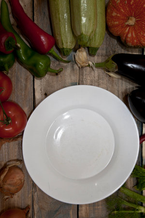 White plate with vegetables on a wooden background. Top view. Selective focus.の写真素材