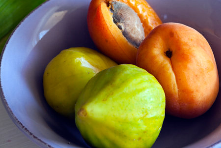 Ripe apricots in a bowl on a wooden table.の写真素材