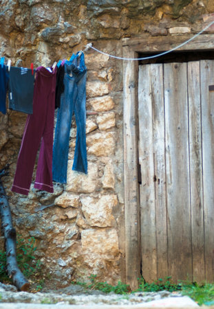 clothes hanging on a clothesline against the background of a stone wallの写真素材
