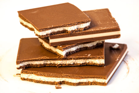 Stack of chocolate bars on a white plate. Selective focus.