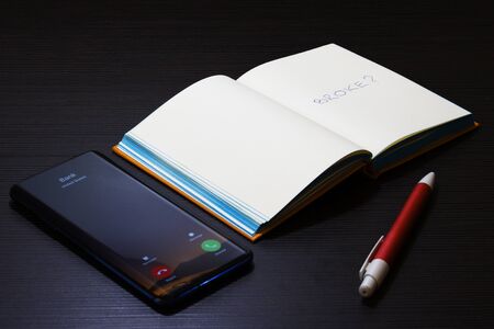 Broke question written on the notepad with bank calling on cellphoneの写真素材