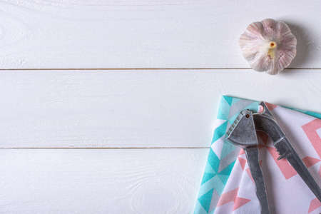 Garlic with garlic press on white wooden background and clothsの写真素材