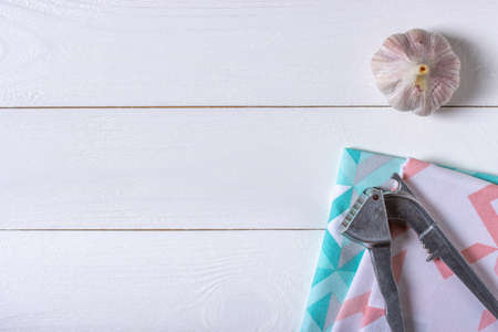 Garlic with garlic press on white wooden background and clothsの写真素材