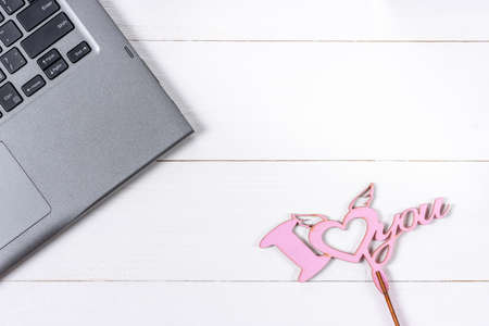 Laptop and love sign on white wooden backgroundの写真素材