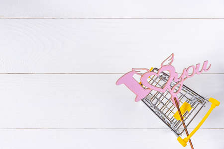Love sign and shopping cart on white wooden backgroundの写真素材