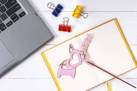 Laptop love sign and notepad on white wooden backgroundの写真素材