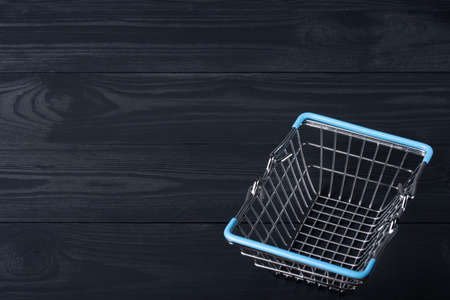 Empty shopping basket on a black wooden backgroundの写真素材