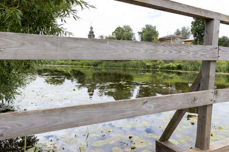 Pond with still water and wooden bridgeの写真素材