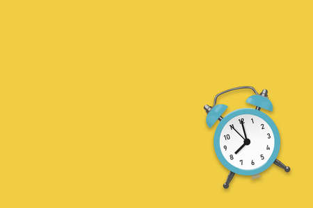 Cyan round alarm clock on the yellow background illustrationの写真素材