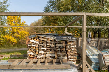 Firewood in woodpile, prepared for Winter. Pile of firewood. The firewood background. A stack of neatly stacked, dry firewood outdoors.の写真素材