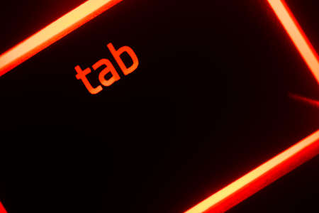 Hazy red illuminated keyboard tab key closeupの写真素材
