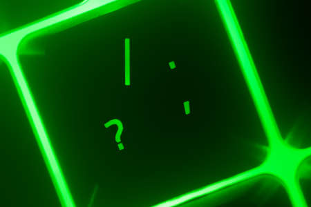 Hazy green illuminated keyboard question key closeupの写真素材