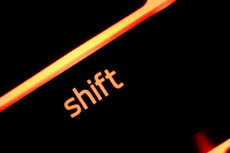 Red illuminated keyboard shift key closeup