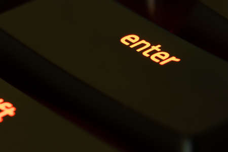 Red illuminated keyboard enter key closeupの写真素材