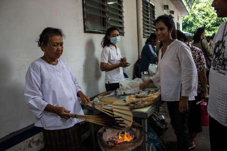 SINGBURI, THAILAND-AUGUST 15  Unidentified people preparing grilled bread for free to people who come to make merit at the temple lost them  On my birthday Charan  The AmpawanTemple on August 15,  2013 AmpawanTemple Phrom Buri district  Sing Buri Provinceのeditorial素材