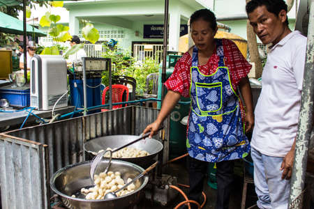 SINGBURI, THAILAND-AUGUST 15 : unidentified people frying meatballs, free for people who join the anniversary of birthdays father Charan at AmpawanTemple on August 15, 2013 AmpawanTemple Phrom Buri  district  Sing Buri Province, Thailandのeditorial素材