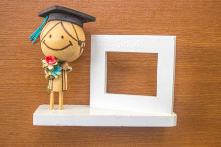 Doll picture frame-white with a wooden background.の写真素材