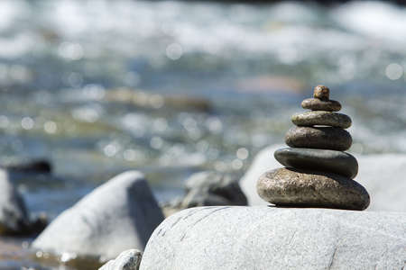 pyramid of stones near the river waterの写真素材