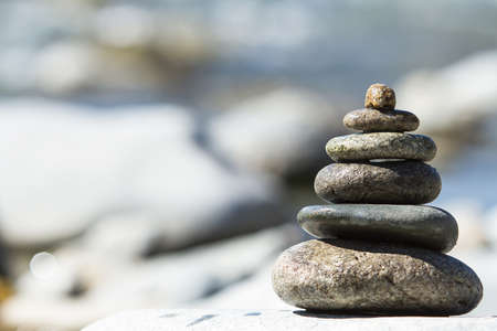 pyramid of stones near the river waterの写真素材