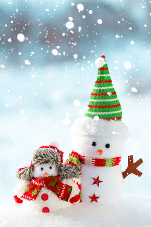 Two snowmen big and small stand in the snowの写真素材