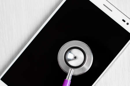 Stethoscope over smartphone screen - studio shootの写真素材