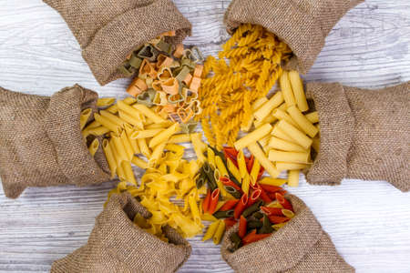 Various mix of pasta on wooden rustic background, sack. Diet and food concept. diversityの写真素材