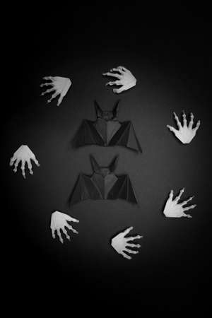 Halloween black background. White hands in a circle in the center of the circle batの写真素材