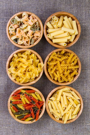 Various mix of pasta on wooden rustic background, sack. Diet and food concept. diversityの写真素材