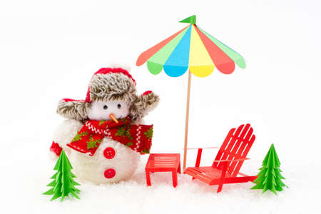 Christmas background, Snowman with sun lounger and beach umbrella. Winter holidaysの写真素材
