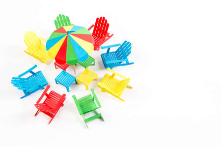 Bright umbrellas folding chairs are made of paper on a white backgroundの写真素材