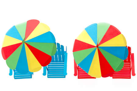 Bright umbrellas folding chairs are made of paper on a white backgroundの写真素材
