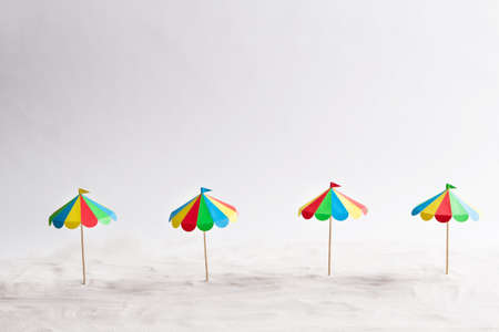 Four beach umbrella on the sand paper. White backgroundの写真素材