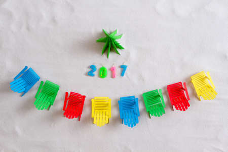 Multi-colored deck chairs around the Christmas tree made of paper. White backgroundの写真素材
