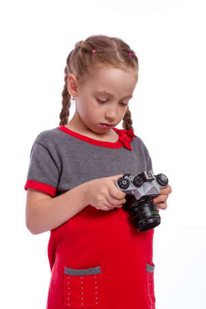 beautiful little girl holding in hands the camera, on white backgroundの写真素材