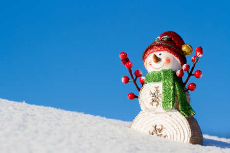 The winter, Christmas - a happy snowman costs on the snow mountainの写真素材