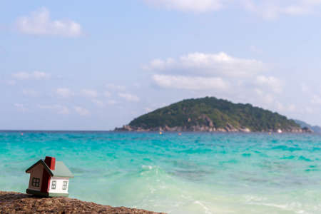 A toy house on a background of sea waves. Sandy beach.の写真素材