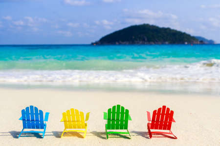 Beach chairs on the sandy beaches for tourists to sit and relax in the soft ocean waves breaking on the beach. Made of paper.の写真素材