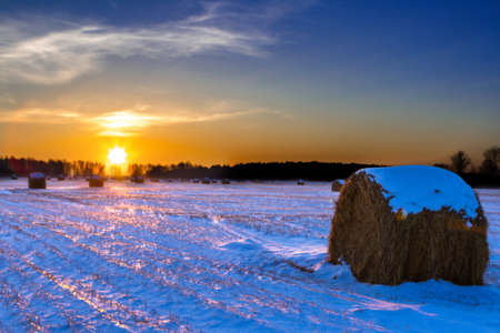 rural field with cut grass, a haystack and the first snow, Russiaの写真素材