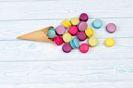 Almond cookies crumbled from waffle cone on light wooden background.の写真素材