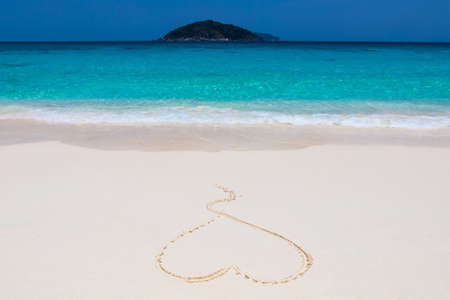 Painted on the sand heart on the snow-white sand. against the background of the island. Similan Islandsの写真素材