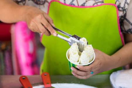 process of making fried ice-cream. Thailand stir-fried ice cream rolls at freeze pan. Organic,...