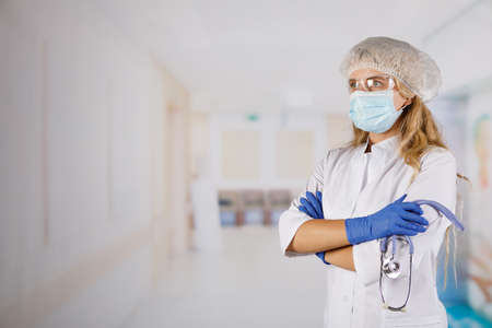 Confident woman doctor wearing medical mask standing with crossed arms. female portrait.の写真素材