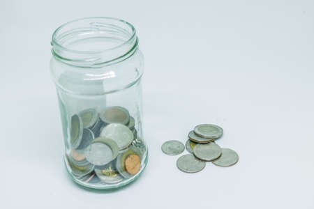 Coin in Glass bottles on white background.の写真素材