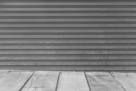 Wood floor in perspective with backdrop metal roller door background.