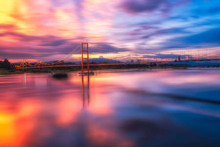 The sun set of old wooden bridge across the river at Tak,Thailandの写真素材