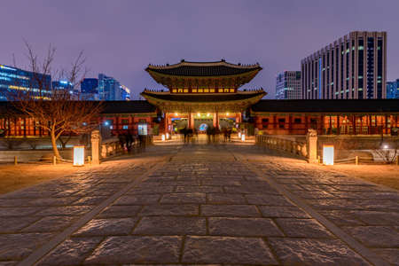 Gyeongbokgung Palace At Night In South Korea, with the name of the palace 'Gyeongbokgung' on a sign