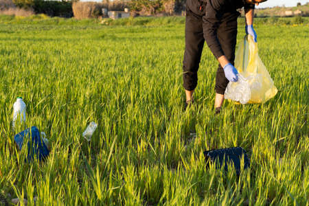 man picking up rubbish from natureの写真素材